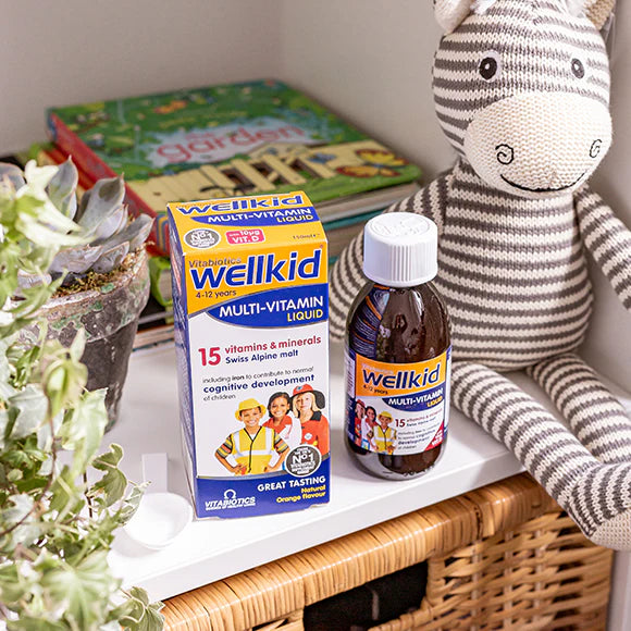 Wellkid Multivitamin syrup Bottle with its box placed on a side table